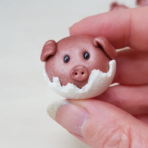 Pigs in blankets tree decor being held between thumb and finger for scale from madebymecrafts