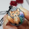 clay fox pendant held between fingers